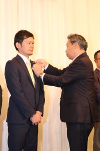 新入会員L新藤へ細川ガバナーより記念バッチの贈呈